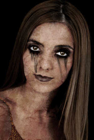 Portrait of a young zombie woman over a black background.