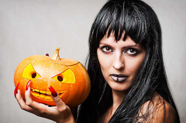Woman witch with black hair with pumpkin