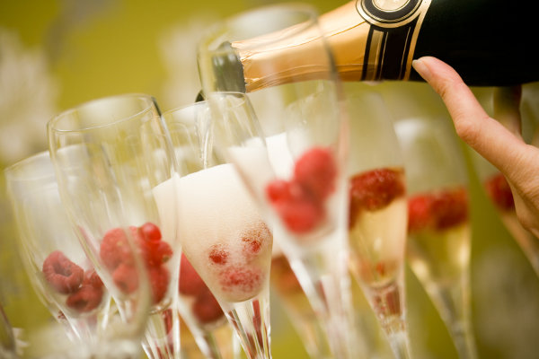 Champagne in glasses with fresh red raspberries